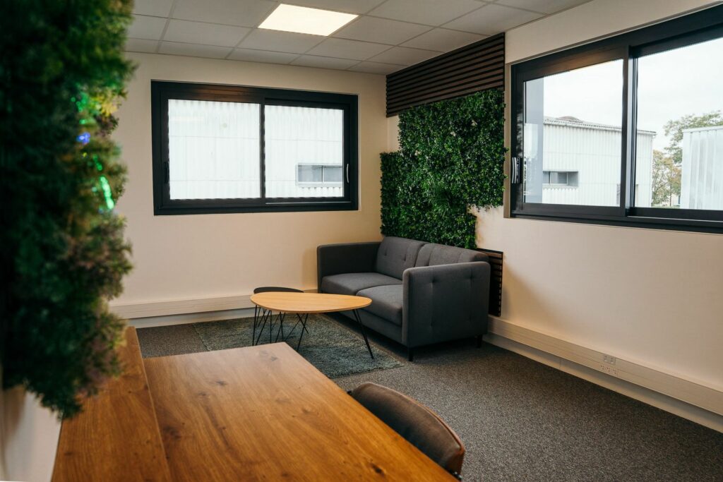 Un bureau thématique avec mur végétal, canapé et table en bois